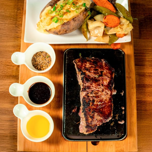 Seared steak on a sizzle plate with sides